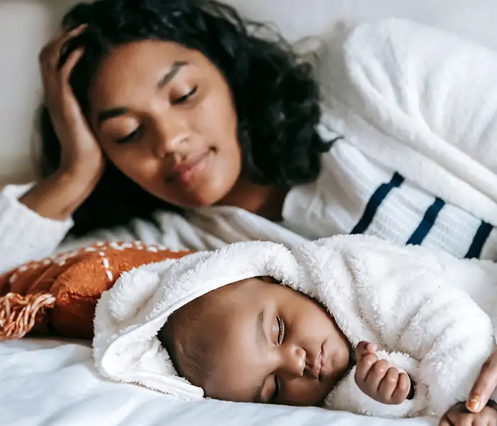 Mother with baby sleeping on a bed